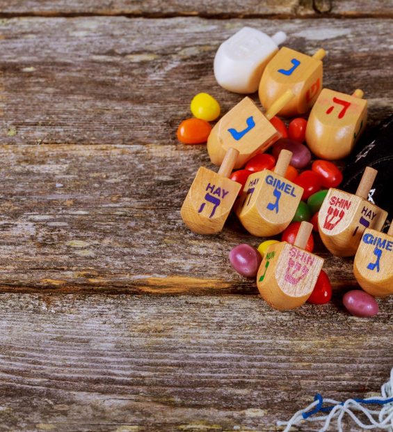 Image of jewish holiday Hanukkah with wooden dreidel spinning top on the glitter background